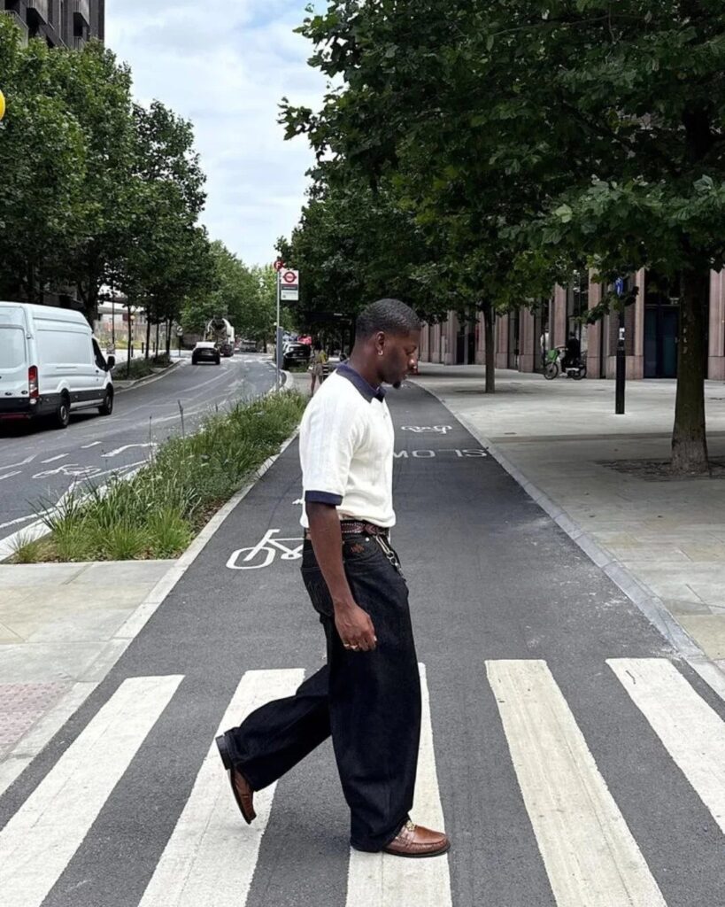 Man in white polo and navy trousers wearing brown leather shoes crossing street