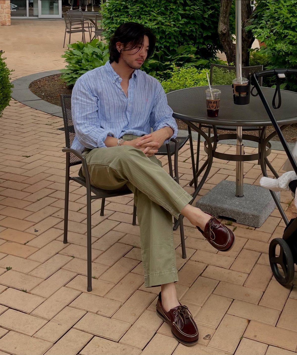 Man wearing a blue striped shirt, olive pants, and brown leather boat shoes.