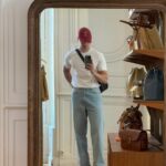 Man in white t-shirt and light blue jeans wearing black penny loafers.