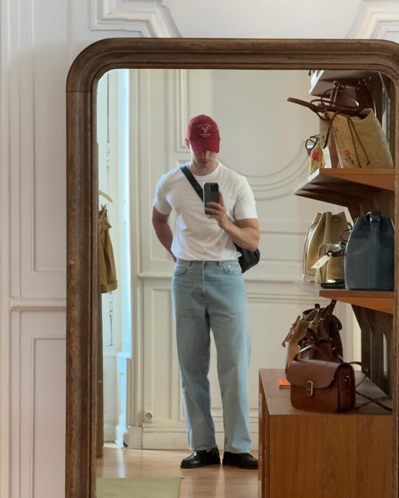 Man in white t-shirt and light blue jeans wearing black penny loafers.