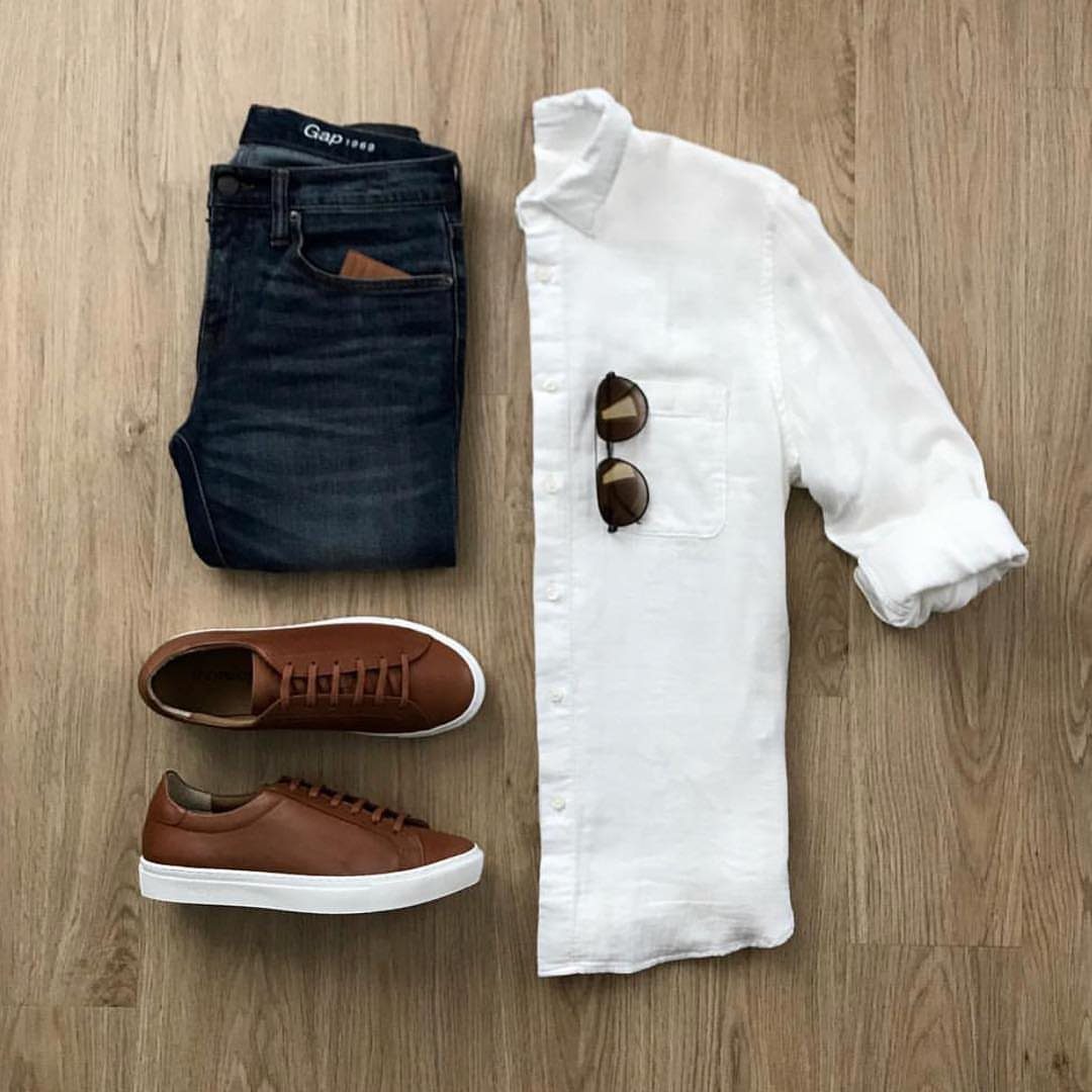 Brown leather sneakers paired with dark blue jeans and a white button-down shirt.